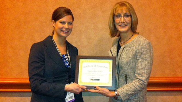 MIA’s Sarah Gregg presents a certificate to Diane Hayden, AKDO’s showroom supervisor. AKDO was named MIA’s CEU Educator of the Year for 2014.